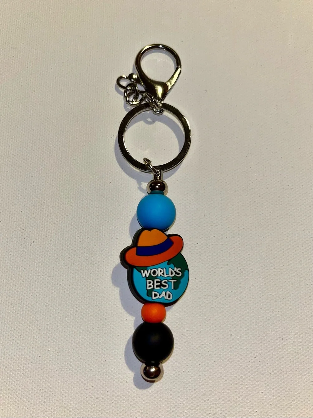 ‘World's Best Dad’ Globe w/Hat Charm Keychain in Blue, Orange & Black